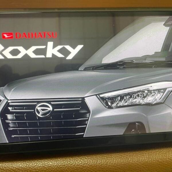 Hands replacing a map SD card in a Toyota Raize dashboard with close-up of NSZN-Y70D card