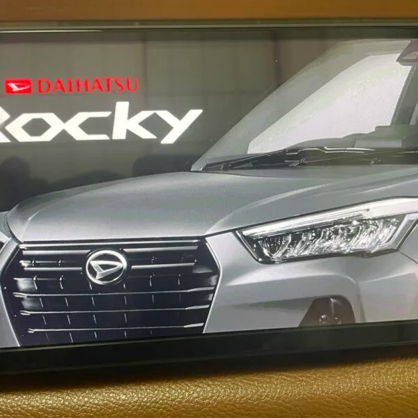 Hands replacing a map SD card in a Toyota Raize dashboard with close-up of NSZN-Y70D card